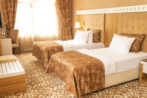 a hotel room with two beds and a window at Graaf Hotel in Baku