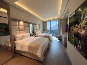a hotel room with two beds and a large window at Safi Royal Luxury Metropolitan in Monterrey