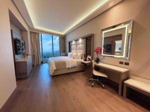 a bedroom with a bed and a desk and a mirror at Safi Royal Luxury Metropolitan in Monterrey