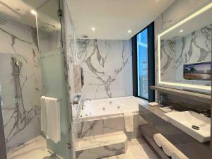 モンテレイにあるSafi Royal Luxury Metropolitanのバスルーム(シャワー、バスタブ、シンク付)