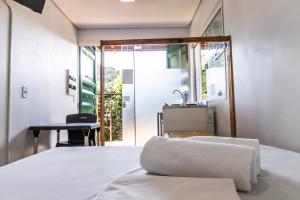 - une chambre avec un lit, une table et un miroir dans l'établissement Praia Camburi - Studios Kuta, à Camburi