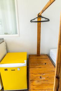 une boîte jaune assise à côté d'une commode en bois dans l'établissement Praia Camburi - Studios Kuta, à Camburi