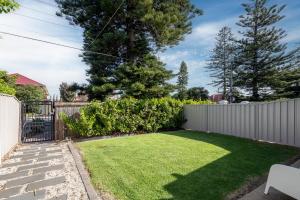 a small backyard with a fence and grass at THE OSLO on Broadway Villa 2 in Glenelg