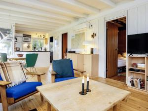 a living room with a table and blue chairs at Holiday home Stubbekøbing III in Stubbekøbing