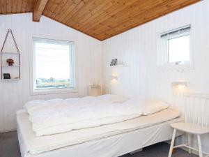 a white bed in a white room with two windows at Three-Bedroom Holiday home in Lemvig 6 in Lemvig
