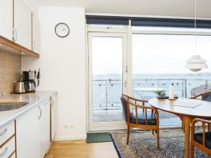 a kitchen with a table and a view of the ocean at Holiday home Hejls XXIX in Hejls