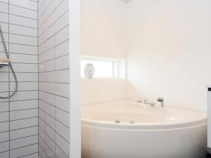 a white bathroom with a sink and a window at 8 person holiday home in Knebel in Knebel