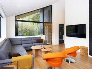 sala de estar con sofá, mesa y sillas en Holiday home Ebeltoft CLXXXVI, en Ebeltoft