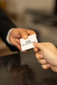 una persona sosteniendo un pedazo de papel en sus manos en Graaf Hotel en Baku