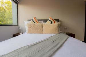 墨西哥城的住宿－Capitalia - Apartments - José Martí，卧室配有带枕头的白色床和窗户。