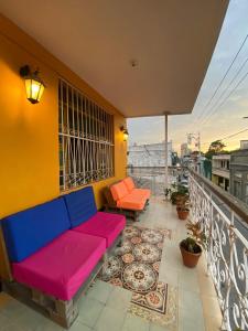 a colorful couch on a balcony with a view at Believer Hostel in Santa Marta