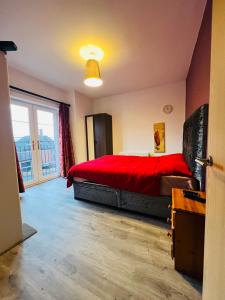 a bedroom with a red bed and a large window at A Perfect homestay near Belfast in Ballyclare