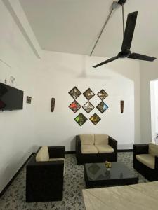 a living room with two couches and a ceiling fan at Believer Hostel in Santa Marta