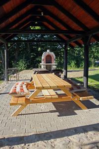 a wooden picnic table sitting under a pavilion at Rafaello Pokoje Gościnne in Łagów