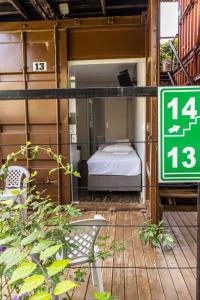 una piccola camera con un letto e un cartello di Praia Camburi - Studios Kuta a Camburi