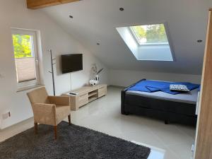 una camera con letto, TV e sedia di balingen-apartments a Balingen