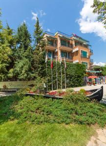 a building with flags in front of a yard at Villa Brigantina in Sunny Beach