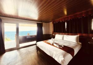 a bedroom with a large bed with a large window at Verde View Villas in Puerto Galera