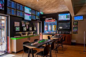 a restaurant with two tables and a bar with televisions at Barossa Brauhaus Hotel in Angaston