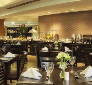Hotel Alphaville Apto 703 في باروري: مطعم بطاولات وكراسي وبار