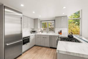 a kitchen with white cabinets and a stainless steel refrigerator at Snowmass Villas 3 bedroom plus loft in Snowmass Village