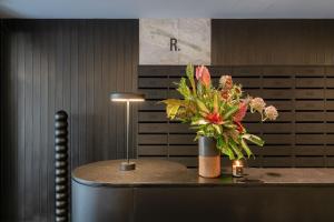 eine Vase Blumen auf einem Tisch in einem Büro in der Unterkunft Tabas - Renata Edifício - Vila Buarque in São Paulo