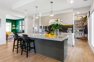 kuchnia z dużą wyspą z krzesłami i kwiatami w obiekcie Craigie’s Hut – Luxury Accommodation on the Mornington Peninsula w mieście Mount Martha