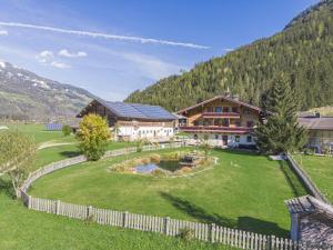 a house with a large yard with a pond at Landhaus Schiedhof in Neukirchen am Großvenediger