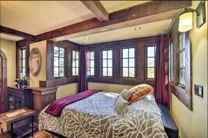ein Schlafzimmer mit einem Bett in einem Zimmer mit Fenstern in der Unterkunft Hacienda - Private Guest Studio in Los Gatos
