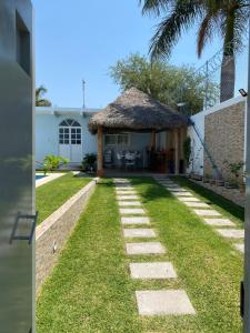 Casa Gaviota Casa Con Alberca y Palapa في تيكواسكيتامو: اطلالة على منزل مع ساحة عشبية