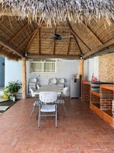 a patio with a table and chairs and a refrigerator at Casa Gaviota Casa Con Alberca y Palapa in Tequesquitengo