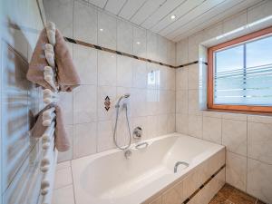 a white bath tub in a bathroom with a window at Flicklhof XL in Penning +25 photos