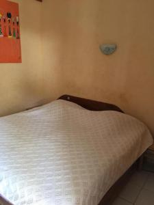 a bed in a bedroom with a white mattress at Ker mame fatou in Sali Nianiaral