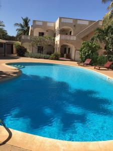 a large blue swimming pool in front of a building at Ker mame fatou in Sali Nianiaral