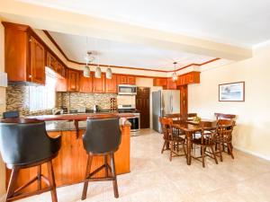 a kitchen with wooden cabinets and a table and chairs at Paradise Villa in Port Elizabeth