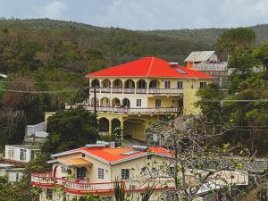 una gran casa amarilla con techo rojo en una colina en Paradise Villa en Port Elizabeth