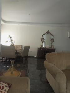 sala de estar con sofá, mesa y espejo en جبل عمان الدوار الخامس, en Amán