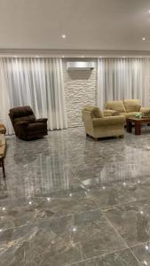 a living room with couches and tables and a stone floor at جبل عمان الدوار الخامس in Amman