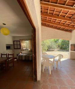 1 dormitorio y patio con mesa y sillas. en Hospedajes Serranos, Cabañas Aaron, solo acepto reservas por privado en Villa Las Rosas