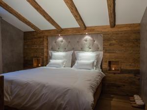 a bedroom with a large white bed with wooden walls at Kitz Boutique Chalet am Lift in Kirchberg in Tirol