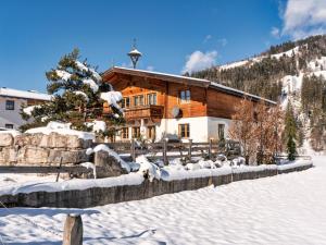 una cabaña de madera en la nieve en frente en Kitz Boutique Chalet am Lift, en Kirchberg in Tirol