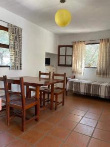 comedor con mesa, sillas y cama en Hospedajes Serranos, Cabañas Aaron, solo acepto reservas por privado en Villa Las Rosas