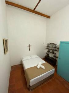 een slaapkamer met een bed met een kruis aan de muur bij Mi casita “Chinco” estrellas in Zapatoca