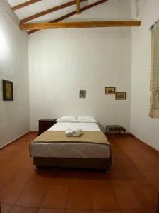 een slaapkamer met een bed in een witte kamer bij Mi casita “Chinco” estrellas in Zapatoca