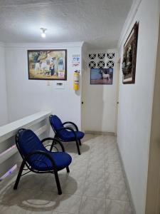 a hallway with two blue chairs in a room at HOTEL CASA BLANCA in Popayan