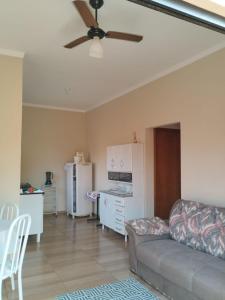ein Wohnzimmer mit einem Sofa und einem Deckenventilator in der Unterkunft RECANTO DA JULINHA in Olímpia