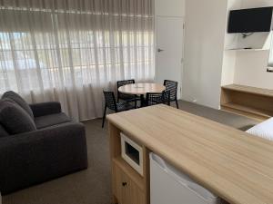 a hotel room with a couch and a table and chair at Guichen Bay Motel in Robe