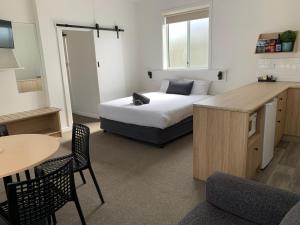 a bedroom with a bed and a table and chairs at Guichen Bay Motel in Robe