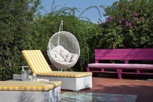 Villa Gianturco - Luxury In The Green Island في ايسكيا: أرجوحة مع كرسي وطاولة ومقعد