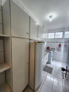 桑托斯的住宿－ÓTIMO APARTAMENTO - UMA QUADRA DA PRAIA EM SANTOS，厨房配有白色橱柜和冰箱。